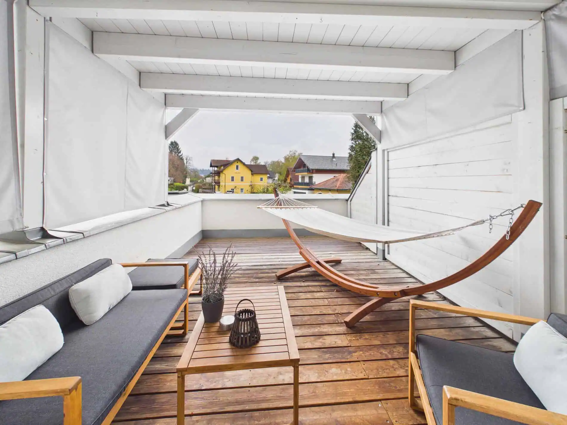 Große Terrasse der Ferienwohnung Adria Villa in Velden mit Sitzgruppe und Blick auf die Berge